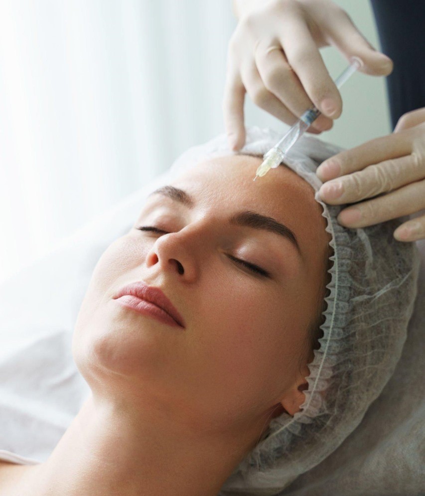 A woman receiving a facial treatment at a Mediversity, with a professional aesthetician attending to her skin.