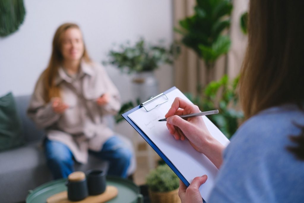 Woman discussing anxiety symptoms with a mental health professional taking notes
