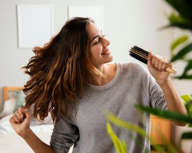 Smiling woman brushing her healthy, full hair