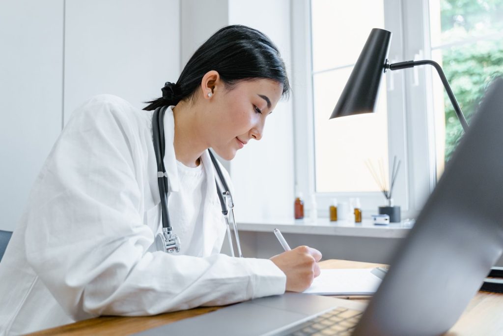Physician writing a personalized medical weight loss plan at her desk