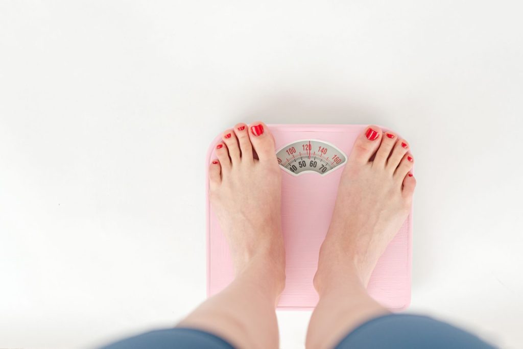 Person standing on a bathroom scale to track medical weight loss progress
