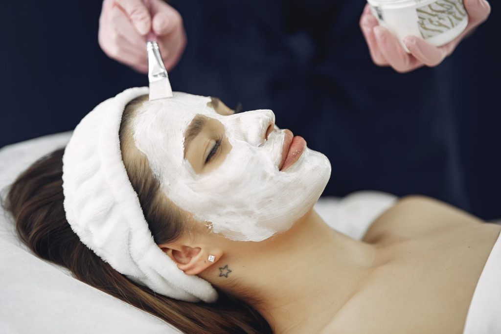 Woman with a facial treatment mask during a professional skin care procedure