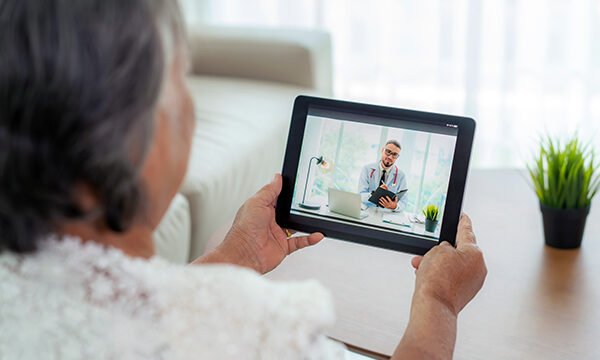Older woman holding a tablet during a virtual visit with an online doctor in New Jersey