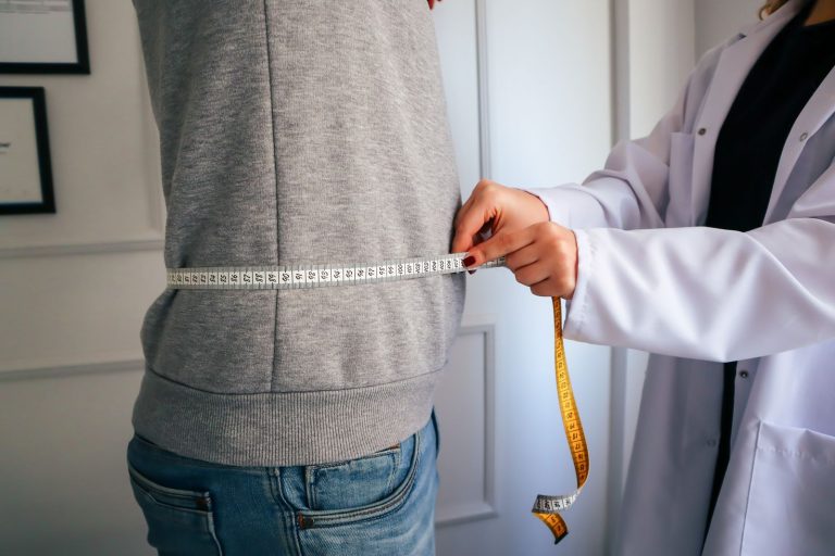 Clinician measuring a patient's waist during a physician-supervised weight loss visit in Turnersville, NJ